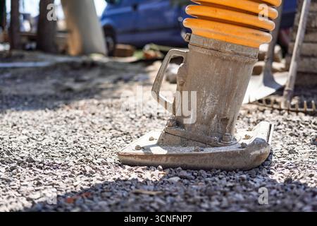 Compattatore per ghiaia o compattatore vibrante portatile in cantiere, dettaglio sulla parte inferiore della macchina Foto Stock