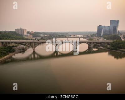 Vista aerea del centro di Saskatoon, Saskatchewan, con fumo di fuoco che incanta lo skyline e la valle del fiume. Foto Stock