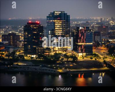 Vista aerea notturna del centro di Saskatoon, Saskatchewan, con lo skyline della città, i ponti e le strade illuminate. Foto Stock