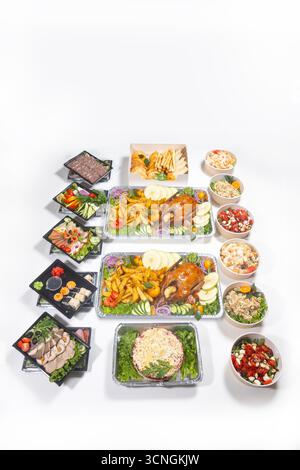 Varietà di piatti festivi, spuntini, carne, insalate, verdure, e panetteria in contenitori e piatti. Foto piatta per il cibo per consegna, annunci e menu. Foto Stock