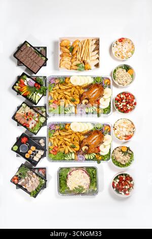 Varietà di piatti festivi, spuntini, carne, insalate, verdure, e panetteria in contenitori e piatti. Foto piatta per il cibo per consegna, annunci e menu. Foto Stock