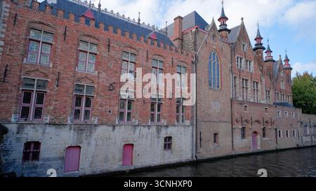 BRUGES, BELGIO - 15 SETTEMBRE 2025 - edifici storici in mattoni con finestre distintive che costeggiano il canale Groenerei a Bruges Foto Stock