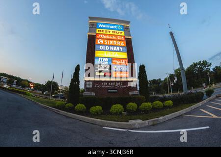New Hartford, New York - 9 agosto 2025: Vista notturna del cartello in pilone di New Hartford Consumer Square Foto Stock