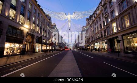 LONDRA, REGNO UNITO. 17 DICEMBRE 2016. Regent Street risplende di decorazioni illuminate degli angeli natalizi all'ora blu, mentre la folla serale si diverte a festeggiare Foto Stock