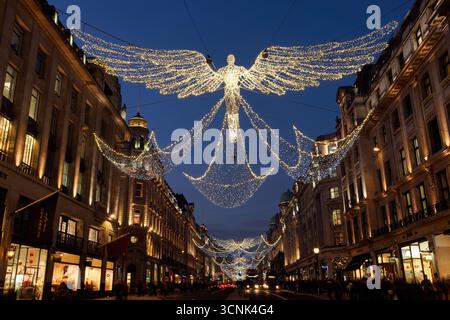 LONDRA, REGNO UNITO. 17 DICEMBRE 2016. Regent Street illuminata con decorazioni di angelo di Natale all'ora blu, mentre gli amanti dello shopping serale si godono le festività. Foto Stock