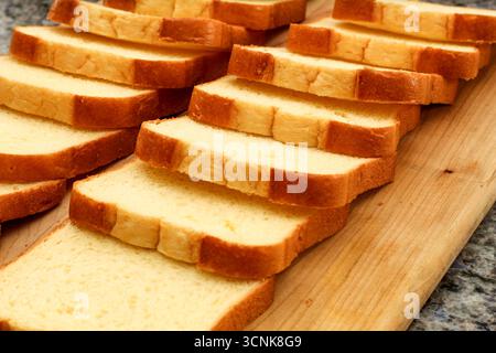 Primo piano di fette di pane su tagliere di legno Foto Stock