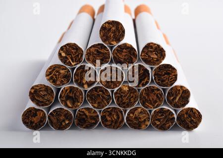 Mucchio di sigarette isolate su sfondo bianco. Fumare porta al cancro ai polmoni Foto Stock