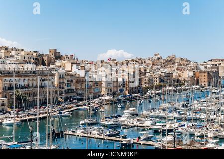 Birgu, Malta - 11 aprile 2025: Vista panoramica del porto turistico di Grand Harbour, con yacht ormeggiati, tradizionali edifici in pietra calcarea tra Birgu (Vittorio Foto Stock