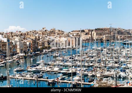 Birgu, Malta - 11 aprile 2025: Vista panoramica del porto turistico di Grand Harbour, con yacht ormeggiati, tradizionali edifici in pietra calcarea tra Birgu (Vittorio Foto Stock