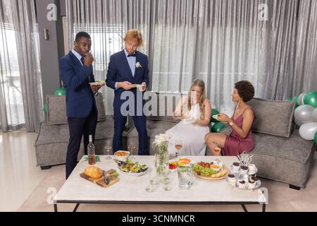 Diverse feste di nozze, assaggio di cibo al tavolo nella sala con bicchieri da vino e palloncini Foto Stock