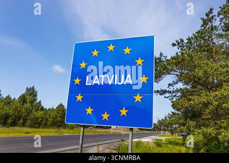 Cartello di frontiera della Lettonia sulla strada di ingresso Schengen dell'UE, stelle blu europee, percorso Baltico Foto Stock