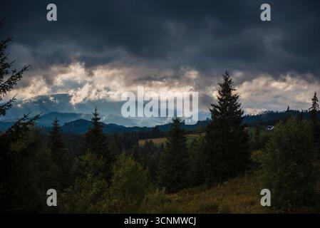 Spettacolare cielo sul paesaggio montano boscoso Foto Stock