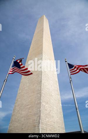Monumento di Washington e bandiere americane che volano Foto Stock