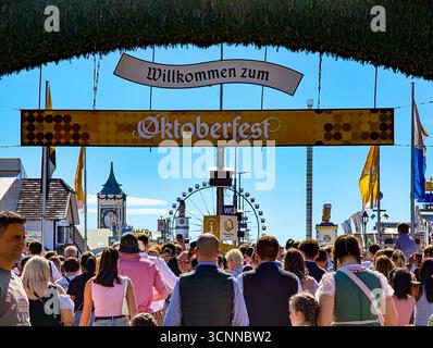 Monaco, Germania. 21 settembre 2025. I visitatori entrano nel parco del festival attraverso il cancello tradizionale dell'Oktoberfest a Monaco, Baviera, Germania, il 21 settembre 2025. (Foto di Michael Nguyen/NurPhoto) credito: NurPhoto SRL/Alamy Live News Foto Stock