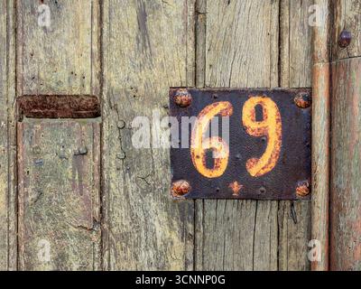 Vecchia casa arrugginita dipinta a mano numero sessantanove / soixante-neuf in Rue Voltaire, Chinon, Indre-et-Loire (37), Francia. Foto Stock
