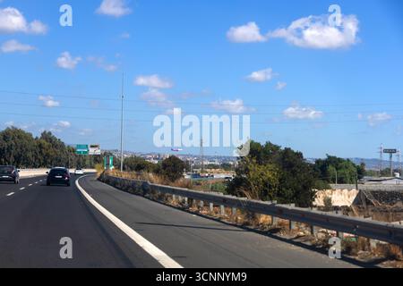 Autostrada con auto sotto il cielo blu nel paesaggio di Catania. Catania, Italia, 22 settembre 2025 Foto Stock