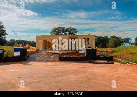 Costruisci una nuova casa prende forma con telai in legno durante il giorno dei lavori nel quartiere in via di sviluppo. Foto Stock