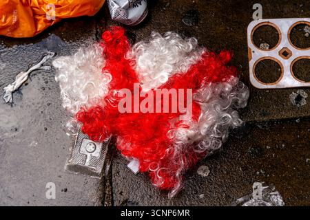 Un cappello/parrucca bandiera inglese giace a terra dopo l'Unite the Kingdom Rally organizzato dall'attivista della Right Wing Tommy Robinson, Londra, Regno Unito. Foto Stock