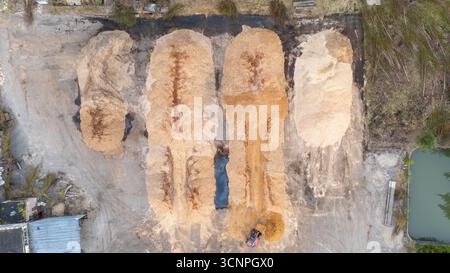 Vista aerea di grandi cumuli di trucioli di legno e segatura in un cantiere industriale. Foto Stock