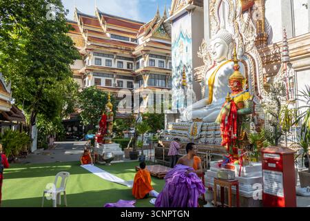 Monaci buddisti che decorano statue al tempio Wat Sutthi Wararam o Suthiwararam, Khwaeng Yan Nawa, Bangkok, Thailandia Foto Stock