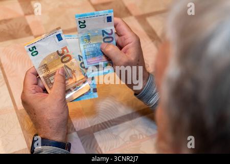 Germania - 21 settembre 2025: Un uomo anziano conta diverse banconote. L'immagine si riferisce alla discussione sulle riforme pensionistiche, sulle decisioni politiche e sulla garanzia del futuro per le generazioni future. *** Ein älterer Mann zählt mehrere Geldscheine. DAS Bild verweist auf die Diskussion um Rentenreformen, politische Entscheidungen und die Zukunftssicherung für kommende Generationen. Foto Stock