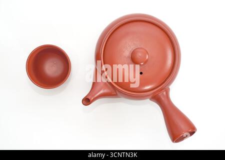 Una foto in studio dall'alto di un tradizionale set da tè giapponese, con una teiera in ceramica marrone kyusu con il suo caratteristico manico laterale e una maniglia coordinata Foto Stock