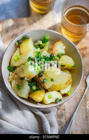 Una vivace insalata greca di patate con teneri patate, capperi ed erbe fresche. Questo piatto rinfrescante è perfetto come pasto leggero o come contorno, traboccante Foto Stock