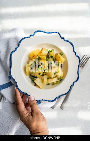 Una deliziosa insalata di patate greche con teneri patate, capperi piccanti e cipolle verdi fresche. Questo piatto rinfrescante, sapientemente condito, è ideale per Foto Stock