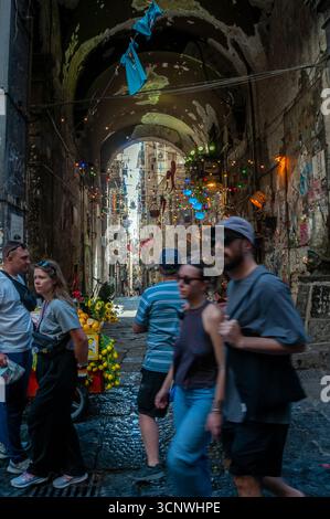 I turisti passeggiano lungo via tribunali vicino a Vico Fico al Purgatorio nel centro storico di Napoli. Foto Stock