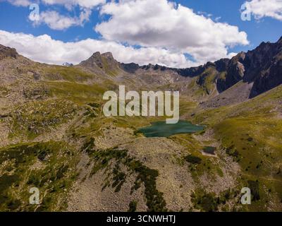 Ampia vista aerea di Palfner SEE nella Terra di Salzburger, Austria, incorniciata da vette alpine, prati verdi e nuvole spettacolari. Un'Europa tranquilla e panoramica Foto Stock