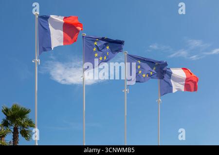 Bandiere francesi e dell'Unione europea che soffiano nel vento. Foto Stock