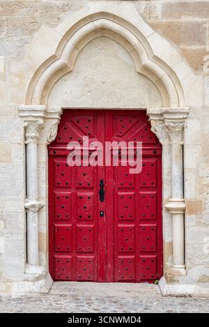 Splendida porta in legno restaurata e dipinta in rosso brillante all'ingresso laterale della chiesa collegiata di San Tommaso di Canterbury. Foto Stock