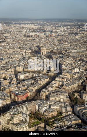 Splendida vista aerea di Parigi in inverno, che mostra l'iconico Arco di Trionfo in mezzo a un vasto paesaggio urbano, invitando i turisti ad esplorare il ch Foto Stock