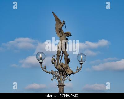 Statua di San Michele su un lampione di Gand - Un dettagliato primo piano della statua di San Michele che uccide il drago, che adorna uno storico lampione Foto Stock