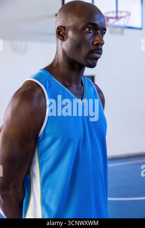 Uomo afroamericano in piedi vicino alla linea foul sul campo con maglia a cerchio, copia spazio Foto Stock
