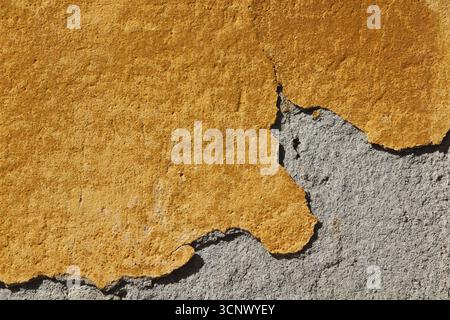 Un dettaglio dalle pareti esterne di un edificio giallo. Parte dell'intonaco si è staccata. Una foto per gli sfondi. Foto Stock