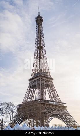 La Torre Eiffel si erge maestosamente contro un cielo mattutino parzialmente nuvoloso, creando una vista pittoresca perfetta per i turisti che esplorano Parigi. Il sereno Foto Stock