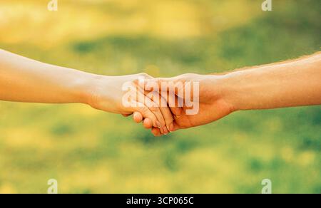 Date una mano. Uomo e donna che stringono la mano contro la natura Foto Stock