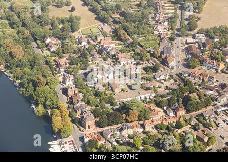 Vista aerea della piccola città con case e strade. Alberi verdi e fiume per insediamento. Panorama urbano dall'alto. Architettura residenziale. Foto Stock