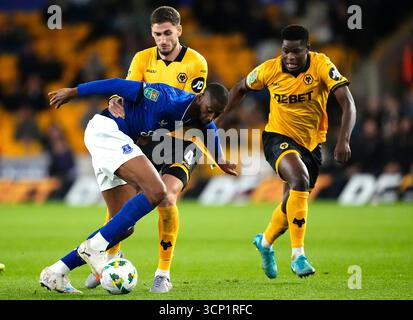 Beto (a sinistra) dell'Everton e Santiago Bueno dei Wolverhampton Wanderers si battono per il pallone mentre Marshall Munetsi (a destra) dei Wolverhampton Wanderers guarda durante la partita del terzo turno della Carabao Cup al Molineux Stadium di Wolverhampton. Data foto: Martedì 23 settembre 2025. Foto Stock