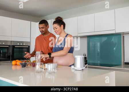 Abbina la frutta a un'isola da banco in una cucina moderna con base del frullatore elettrico Foto Stock