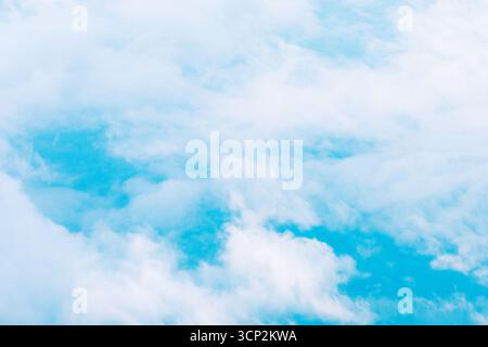 Cielo blu pieno di morbide nuvole bianche, che creano un'atmosfera serena ed espansiva. Le nuvole sono sparse, rivelando macchie di cielo limpido, suggerendo Foto Stock