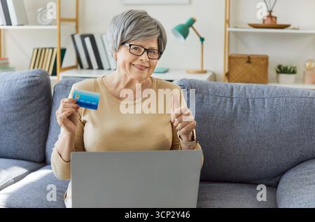 Donna anziana di un cliente bancario maturo che effettua pagamenti online con carta di plastica, carta di credito, pagamento Foto Stock