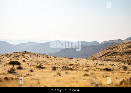 Un luogo per picnic si affaccia sul vasto deserto del Namib dal passo Spreetshoogte, con pianure nebbiose e aspre montagne Foto Stock