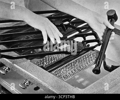 Primo piano che mostra la rimozione per la pulizia del rack per pentole di un forno Vulcan. Da una fotografia stampata che originariamente apparve nella pubblicazione, The Vulcan Cook Book, che fu pubblicato nel 1936 dalla Vulcan Stove Company di Exeter, Inghilterra. Foto Stock