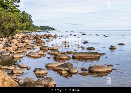 Kaltene Costa rocciosa, Lettonia - litorale del Mar Baltico con massi e acqua calmo Foto Stock