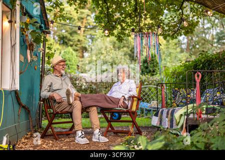 Coppie anziane che si rilassano in giardino insieme Foto Stock