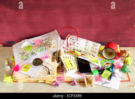 Calendario con appuntamenti e scadenze di lavoro, penne, tazze da caffè e documenti, in un luogo di lavoro disordinato. Il concetto di business batte il tempo, ha lavorato troppo, str Foto Stock