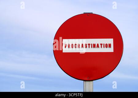 concetto di procrastinazione, parola scritta su un cartello di divieto di traffico Foto Stock