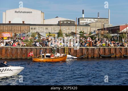 Persone sedute e bevute al sole della sera a Reffen nella zona di Refshaleoen, Copenaghen, Zelanda, Danimarca, Europa Foto Stock